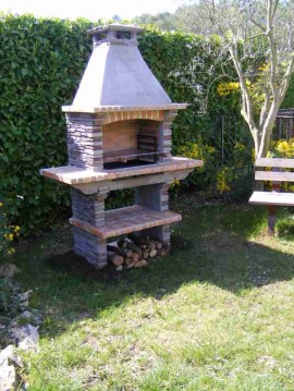 Barbecue en pierre reconstituee avec foyer vertical pour tourne broche