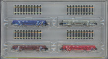 Minitrix 15628 Set van vier lage-bak wagens NS in verschillende kleuren met stukjes rails